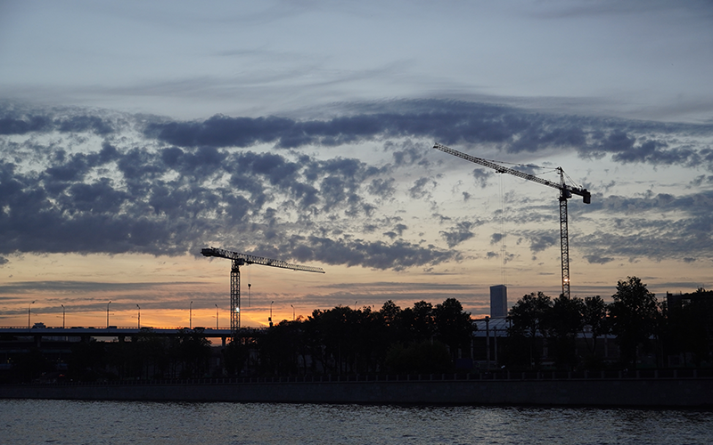 Silhouette of a landscape with cranes. Photo. 