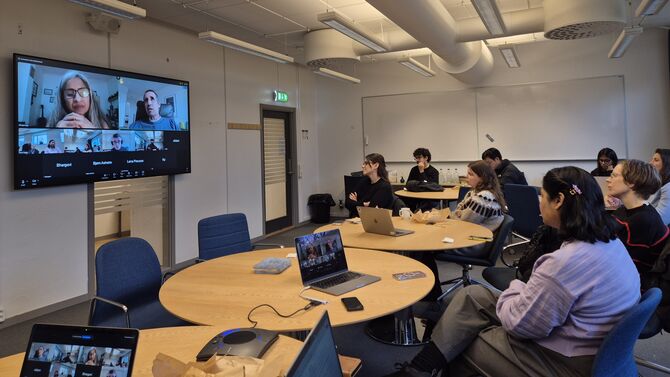 Hybrid meeting with participants on screen and in the room.