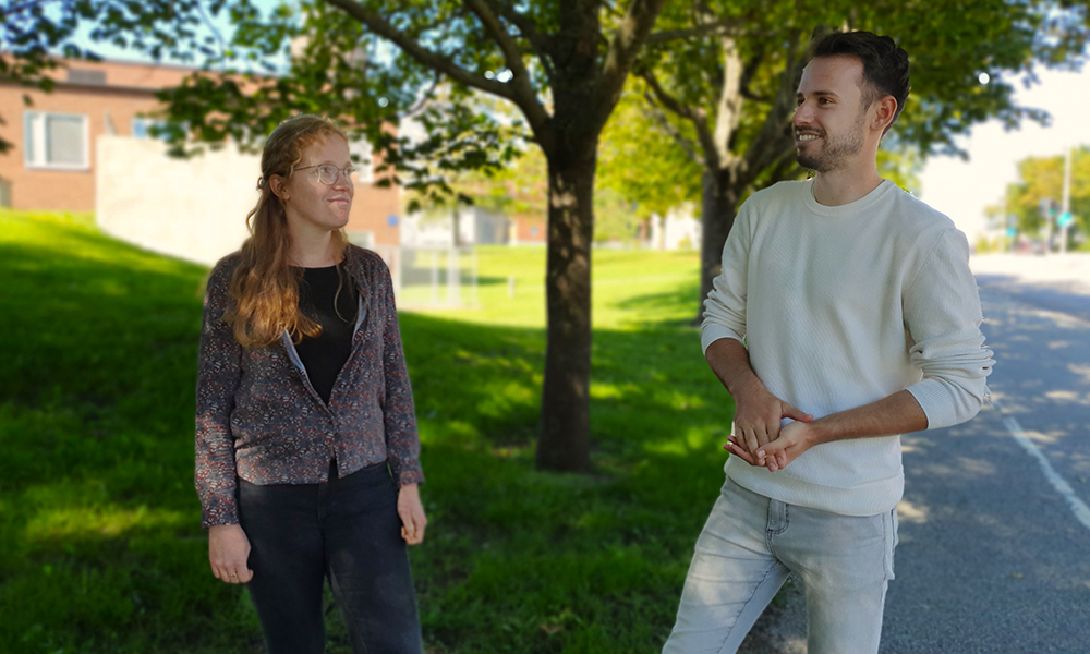 Two peole talking together outdoors. Photo.