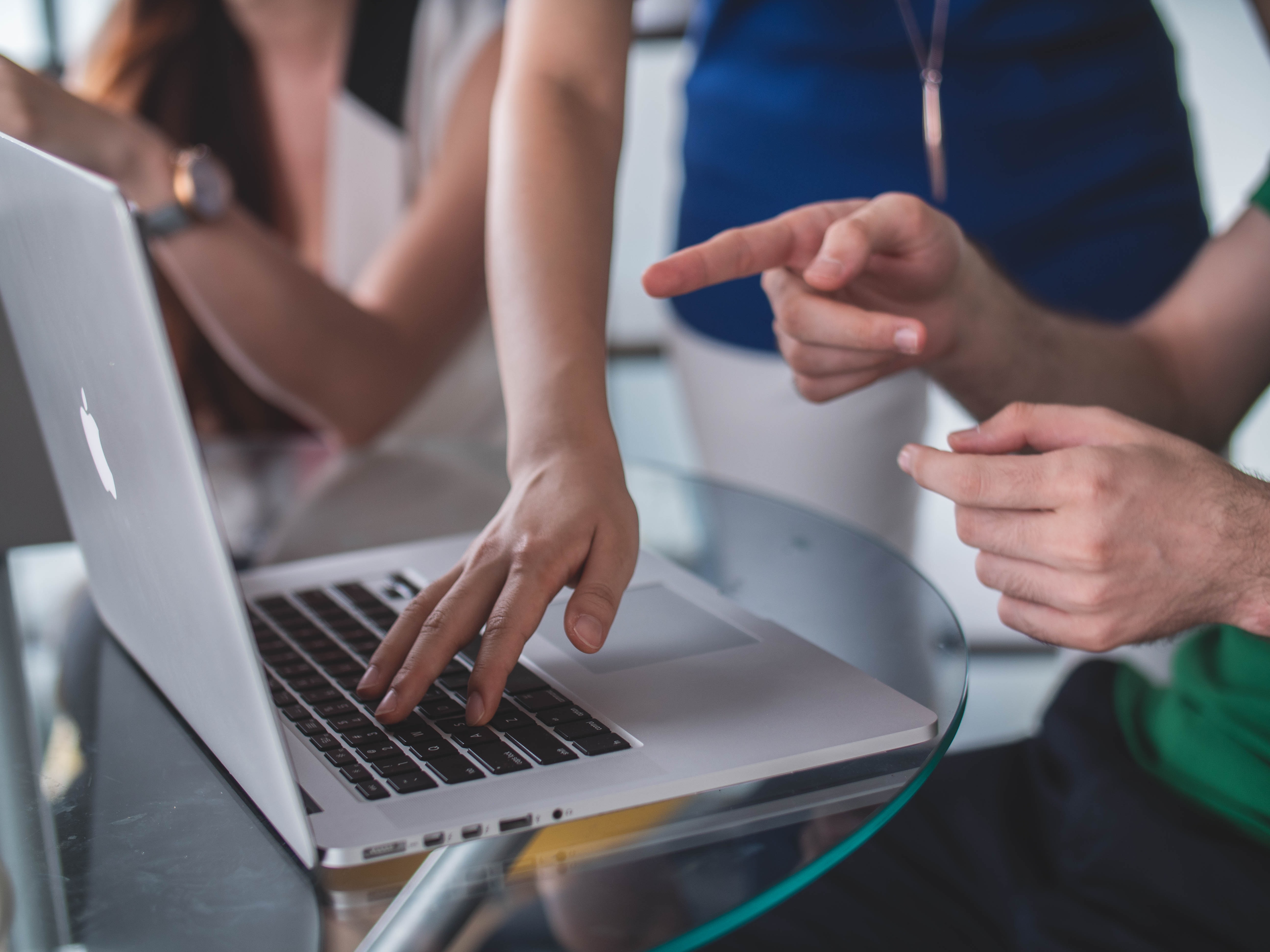 hands pointing at a computer screen. Photo.