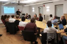 A room full of people listening to one speaker. Photo.