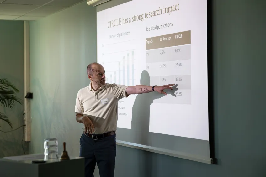 A man pointing at his presentation slide. Photo.
